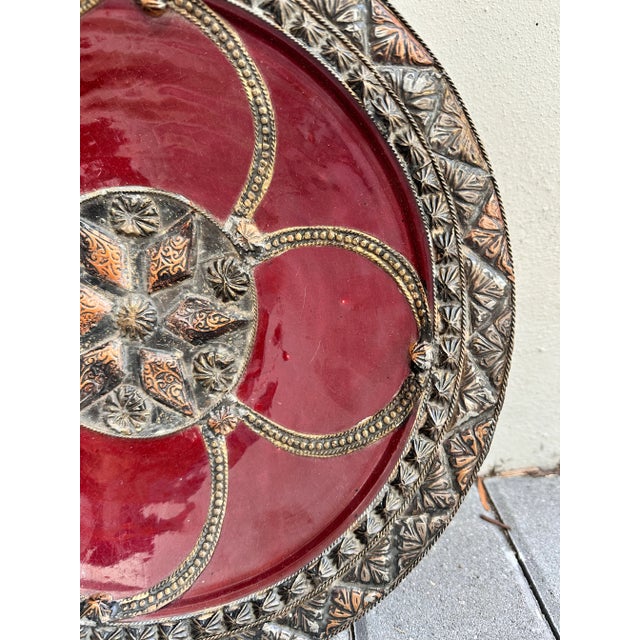 The deep red interior is beautifully contrasted by intricate brass-colored metal inlay, forming a captivating six-point...