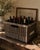 An evocative early-20th-century French wine crate constructed from dark, tightly woven wicker over a substantial wooden...