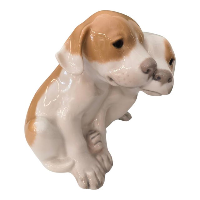 This porcelain figurine, designed by Erik Nielsen for Royal Copenhagen, depicts two Pointer puppies snuggled together. The...