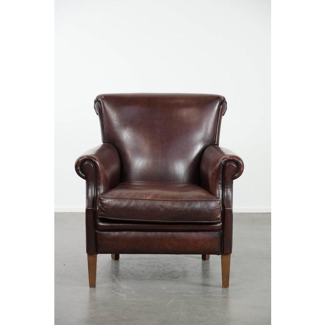 Offered for sale: this luxurious sheepskin armchair with a timeless look and a beautiful dark color. This luxurious...