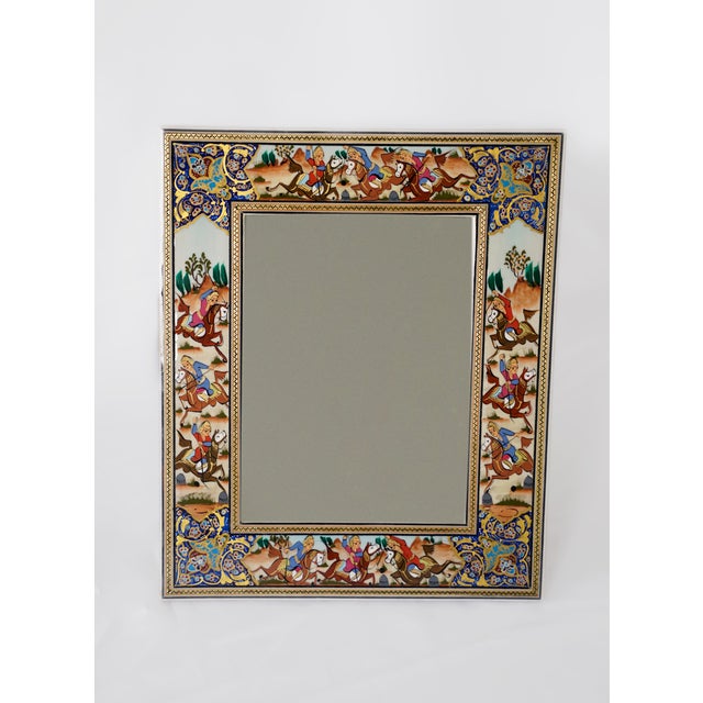 This hand-painted decorative mirror features a traditional polo scene inspired by Persian miniature painting. Horses in...