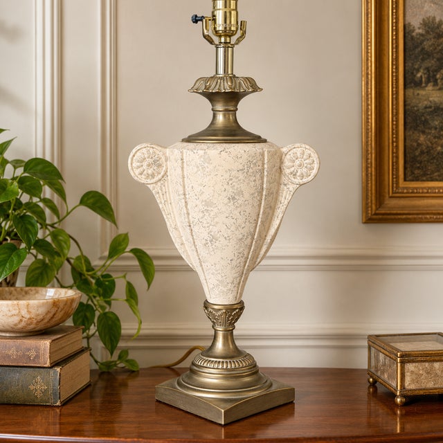 Sculptural vintage Neoclassical table lamp featuring an amphora-inspired ceramic body finished in mottled beige and cream...
