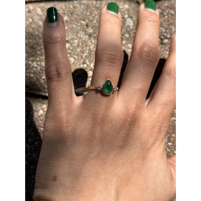 A stunning 1.3ct pear-shaped emerald (9×6mm) set in solid 14K gold, surrounded by sparkling natural diamond accents....