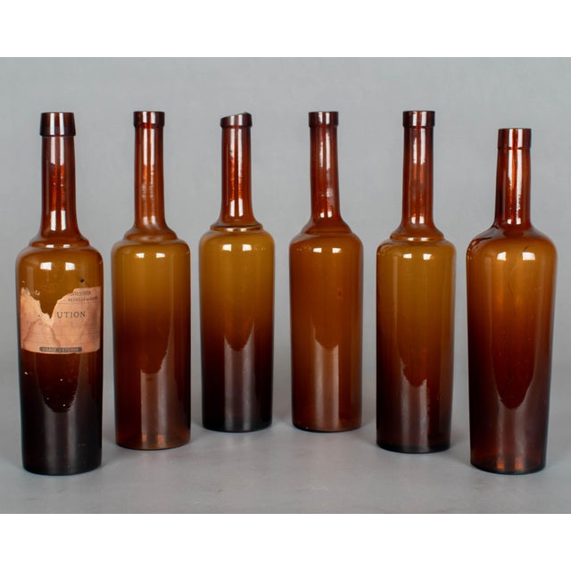 A set of six French amber glass pharmaceutical bottles, one with remnant of paper label. One bottle is slightly different...