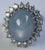 An elegant vintage cocktail ring with a beautiful pale lavender-blue cabochon sapphire surrounded by 20 diamonds in a 14K...