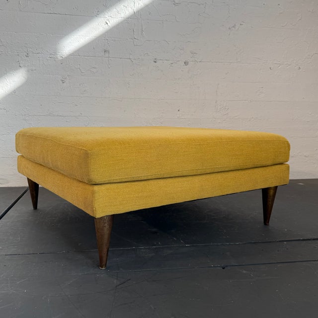 This oversized Mid-Century Modern style square ottoman features a double cushion design upholstered in a mustard-yellow...