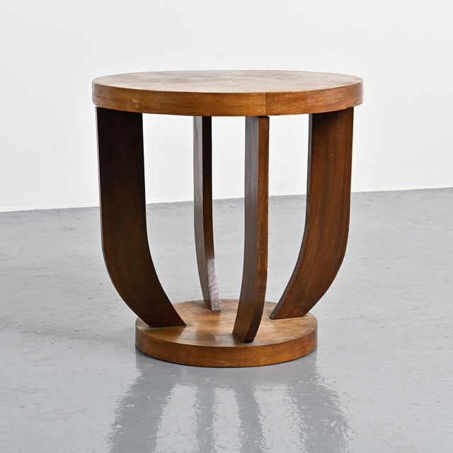 Art Deco side table with a circular top featuring marquetry decoration and resting on four curved legs connecting the top...