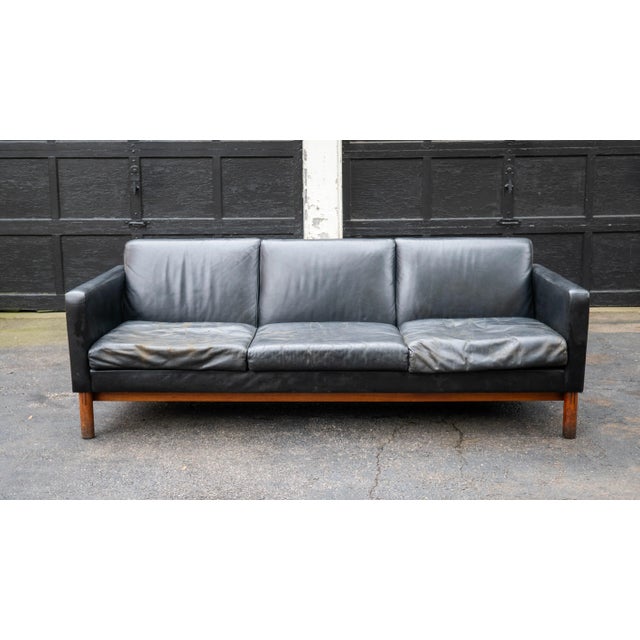 Vintage Mid Century Gunlocke black sofa, circa 1950s. Walnut base and legs. Removable seat cushions. Manufacturer label...