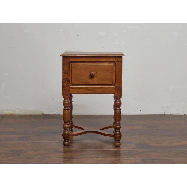 A French walnut side table from the 19th century, notable for its practical sliding door compartment. The rectangular top...