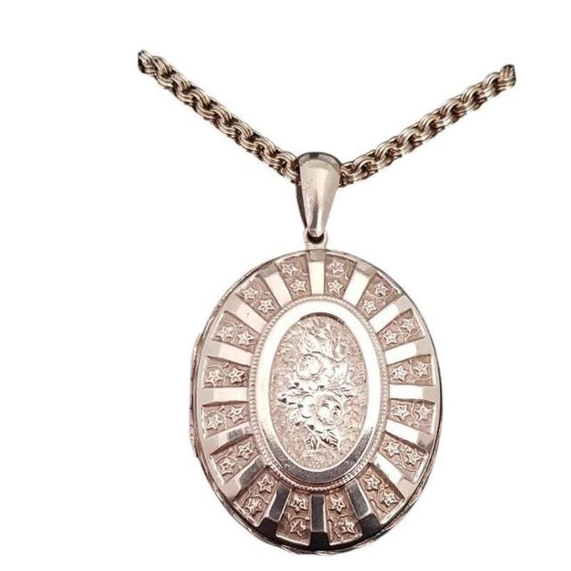 A beautiful late Victorian sterling silver oval locket and chain dating to circa the 1880s, displaying the distinctive...