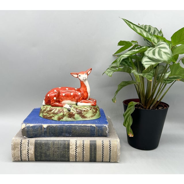 Eye-catching Staffordshire recumbent deer figurine finished in a rich iron-red glaze with hand-applied white spotting. The...
