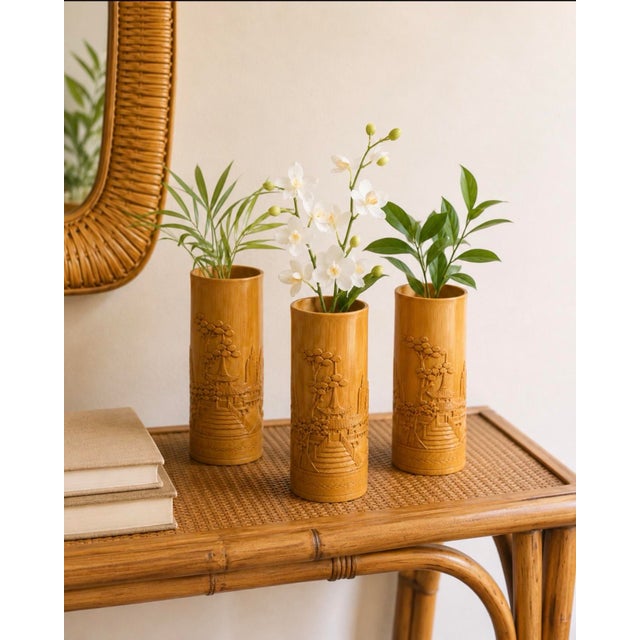 A charming set of three vintage Chinese bamboo bud vases, each hand-carved with detailed landscape scenes featuring...