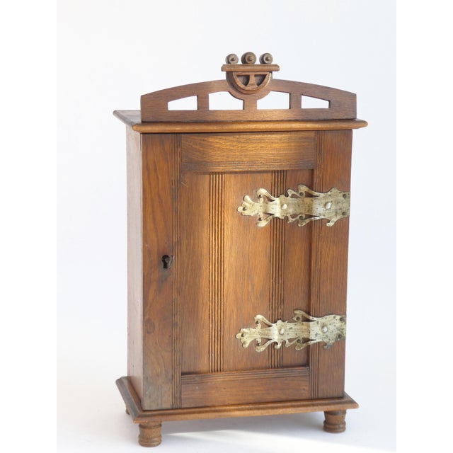 Small Dutch wooden oak cabinet with a beautiful door with brass ornaments in the front. The small chest has a nice...