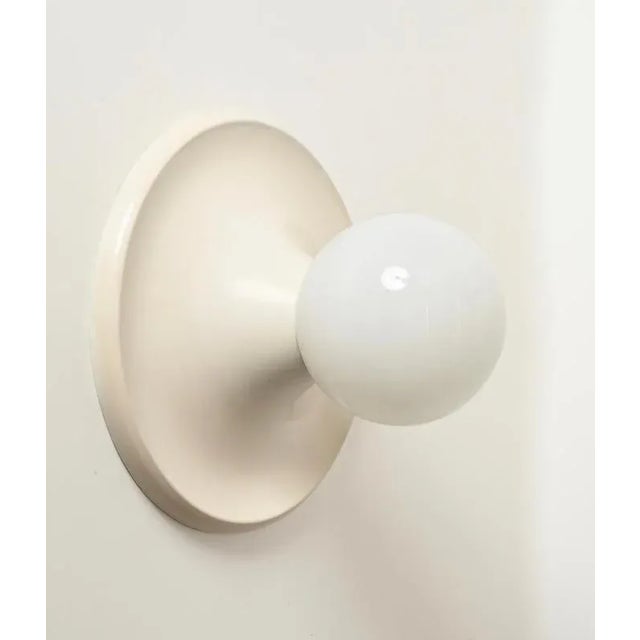 Gorgeous mid-century "light ball" wall or ceiling lamps in a charming ivory-colored enameled metal and opaline glass,...