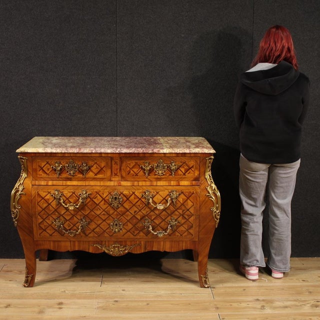 French chest of drawers from the mid-20th century. A curved furniture in the Louis XV style, richly adorned with geometric...