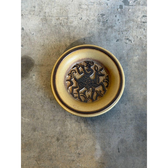 This exceptional studio pottery bowl features a striking relief illustration at its center depicting the mythological...
