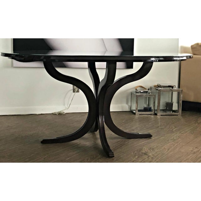 Elegant custom made mahogany oval table with beveled glass top and base in the form of four-legged scrolls. Ideal to...