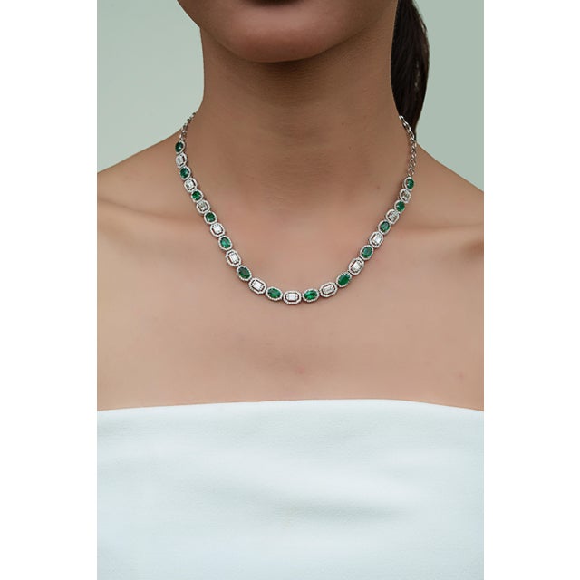 This elegant necklace features 5.71 carats of oval-cut emeralds Crafted in 14K white gold, measuring approximately 6 x 4...