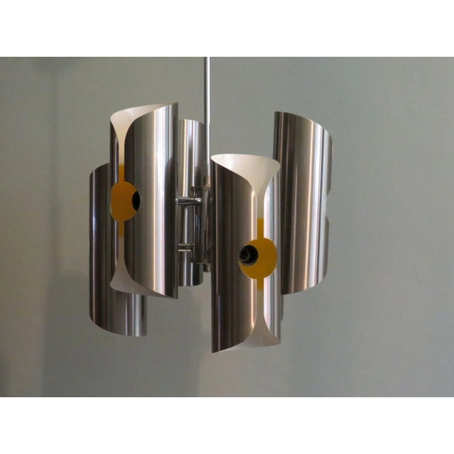 Striking chandelier by Polam 1960-1970. The chandelier has a chrome frame and 6 pleated sleeves in brushed stainless steel...
