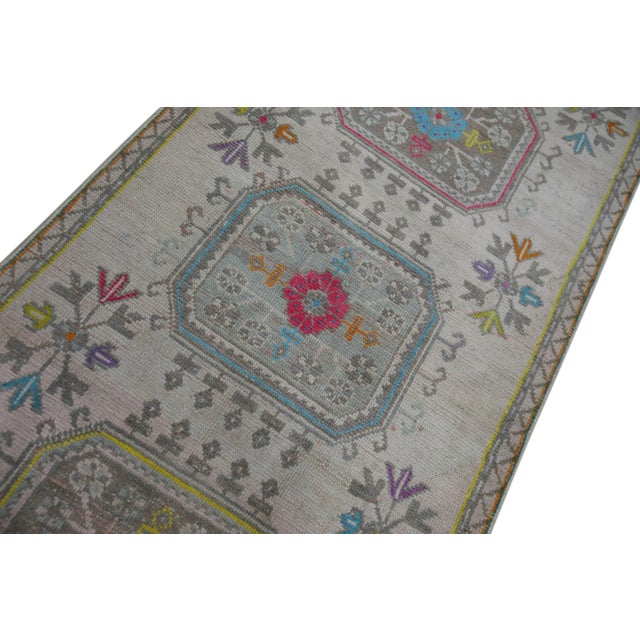 Introducing a one-of-a-kind vintage Turkish hand-knotted wool runner rug, carefully crafted by skilled artisans using...
