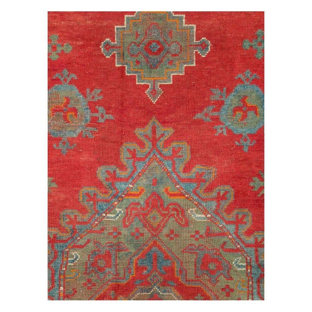 An antique Turkish Oushak rug in gallery format handmade during the early 20th century with a large medallion over a...