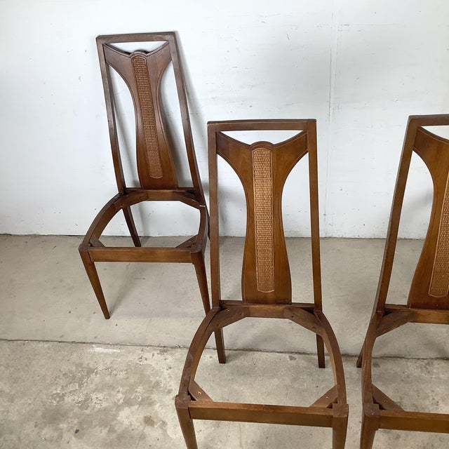 This set of four high-back walnut dining chairs has a back design that stops you: a tall sculpted walnut frame carved into...