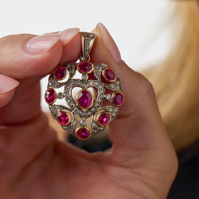 This elegant Mid Century ruby and diamond pendant is a beautifully dramatic jewel from the 1950’s, featuring 9 oval cut...