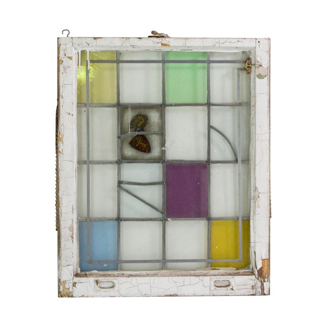 Wood framed window with clear glass and green, yellow, purple, and blue pastel stained glass panes accenting the yellow...