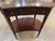 An antique mahogany Hepplewhite end table with a glass top and a drawer. The kidney-shaped tables in the image appear to...