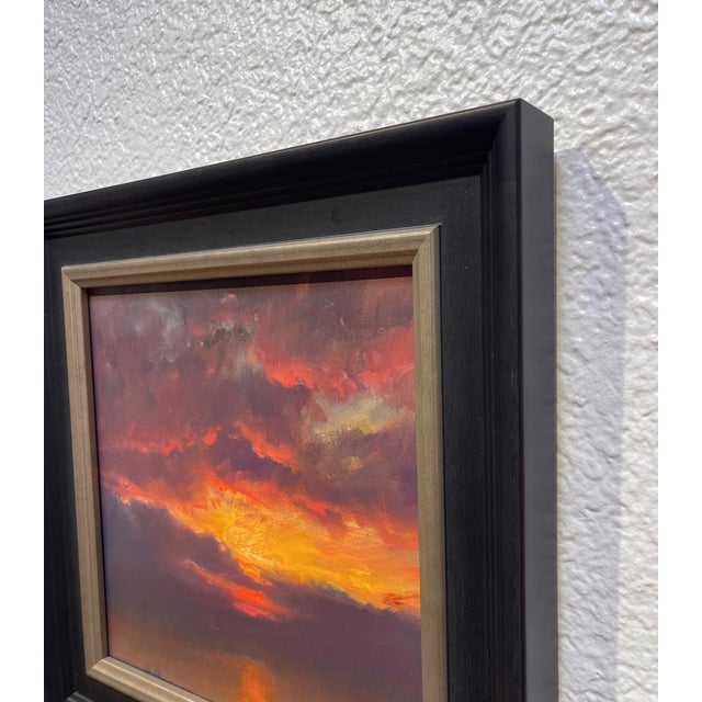 The painting captures a dramatic sunset, with deep purples and fiery oranges blending seamlessly in the sky. The...
