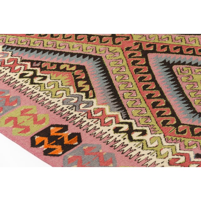 This is a vintage Turkish Oushak rug from the Mid 20th Century. The piece was hand-knotted.
