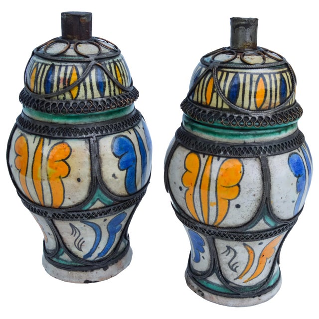 Set of two 19th-century handcrafted and glazed ceramic lidded jars from Fez, Morocco. Each features an intricate hand-...