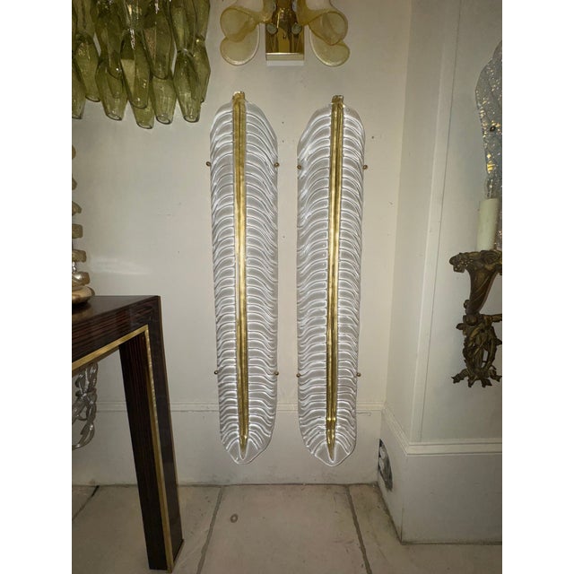 The product is a pair of large scale Murano glass leaf sconces, which are lighting fixtures designed in an elegant and...