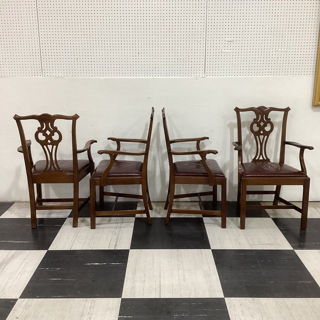 Elegant set of four vintage Chippendale-style dining armchairs featuring beautifully carved pierced splats with shell...