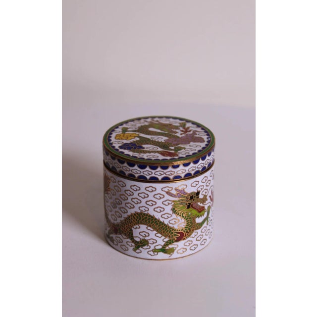 Vintage hand-painted cloisonné enamel trinket box featuring a traditional green dragon motif with gold-tone detailing....
