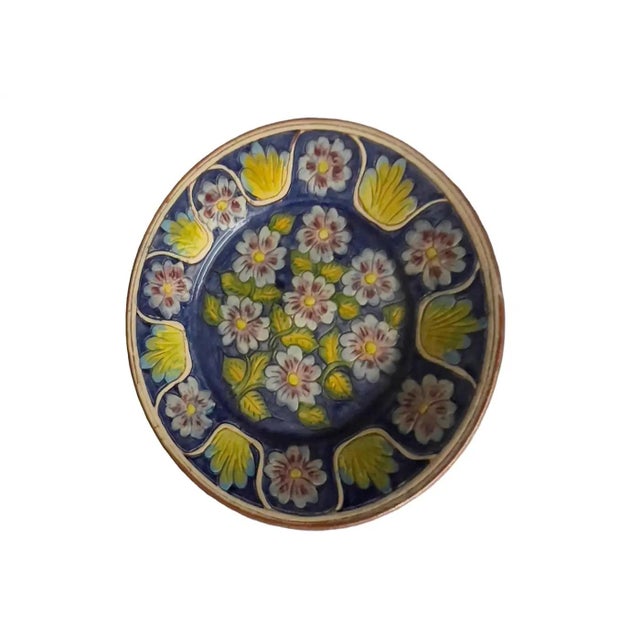 Vintage terracotta plate with a blue and yellow floral design from Spain. Circa 1960s.