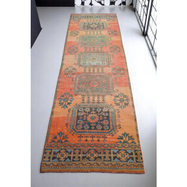 A vintage, distressed Turkish Oushak rug runner with a geometric motif and large design elements. Great aesthetic and worn...