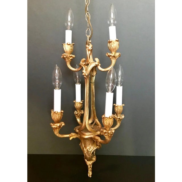The six arms are in the form of swirling acanthus leaves in the exuberant Louis XV style. This finely chased chandelier...