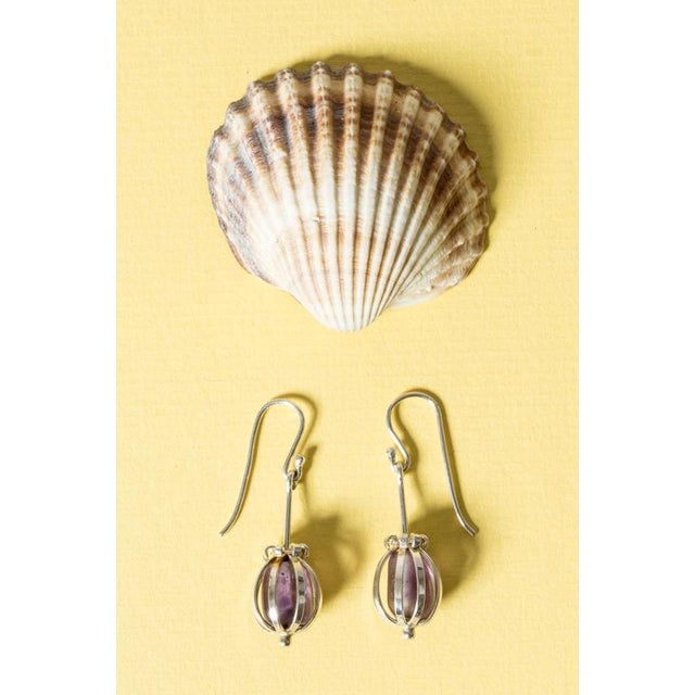 Exquisite silver earrings by Arvo Saarela, with tumbled amethyst stones inside a decorative cage. Beautiful attention to...