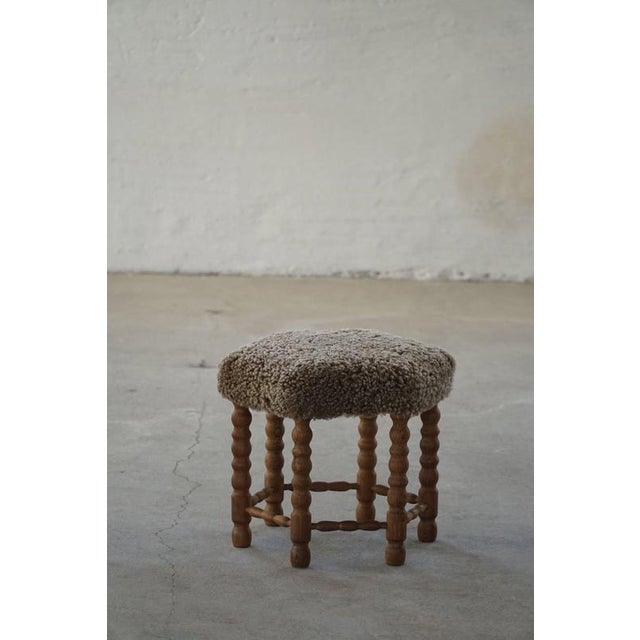 A beautiful Danish modern stool in oak with curly legs, the hexagon seat reupholstered in a great quality shearling...