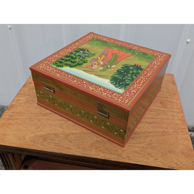 Enhance your home decor with this stunning hand-painted wooden jewelry storage box, featuring a beautiful Indian theme....