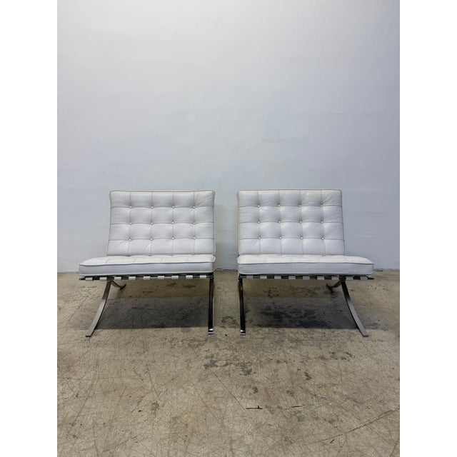 Pair of authentic Barcelona lounge chairs in white leather and 304 polished stainless frames originally designed by Ludwig...