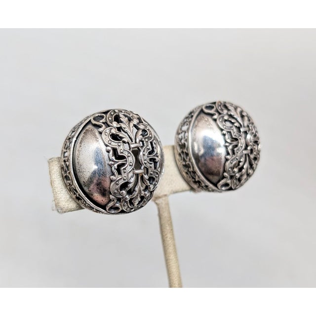 1950s round domed with filigree openwork section down the center and around the sides clip back earrings. Marked "NAPIER...