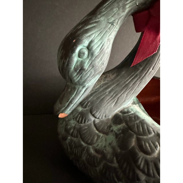 Vintage 1991 Swan shaped Terra cotta planter. It is patina green in color with a removable red bow tied on its neck.