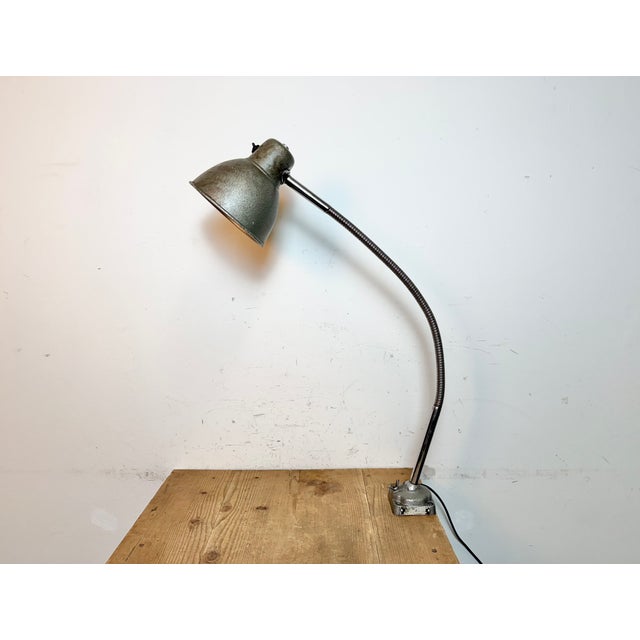 This adjustable gooseneck desk lamp was designed and manufactured in Hungary during the 1960s. It features a green grey...