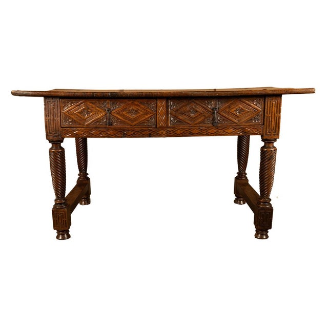 A period antique 17th century Baroque two drawer carved walnut desk or serving table, Navarre, Spain, circa 1650. A...