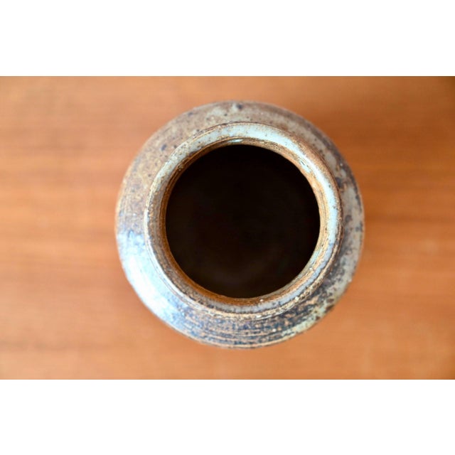 This stoneware vase, crafted from chamotte, evokes the golden age of 1960s ceramic design, somewhere between Scandinavian...