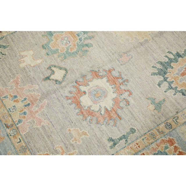 This modern Turkish Oushak rug is a stunning piece of art that has been handwoven using traditional techniques by skilled...