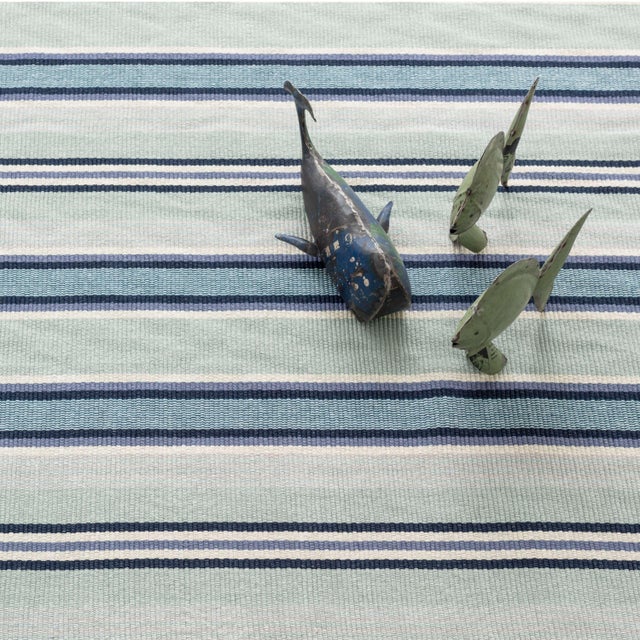 Aquatic shades of blues and greens evoke dreamy tropical waters in this island-style striped, low profile cotton rug. Soft...