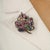 This elegant 9.15 carat multi-gemstone and diamond maple leaf brooch pendant is crafted in 925 sterling silver, featuring...